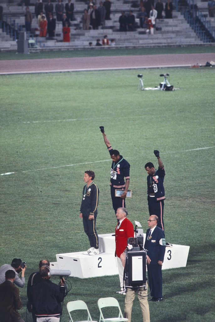 Tommie Smith and John Carlos raise black-gloved fists on the 1968 Mexico City Olympic podium